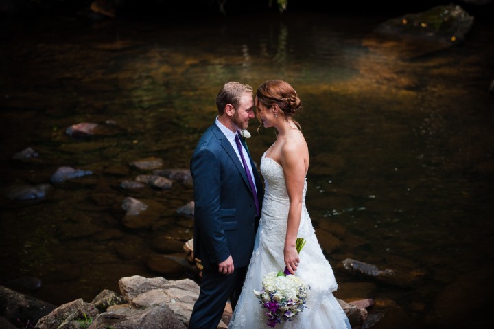 bride and groom take a quiet moment by the river