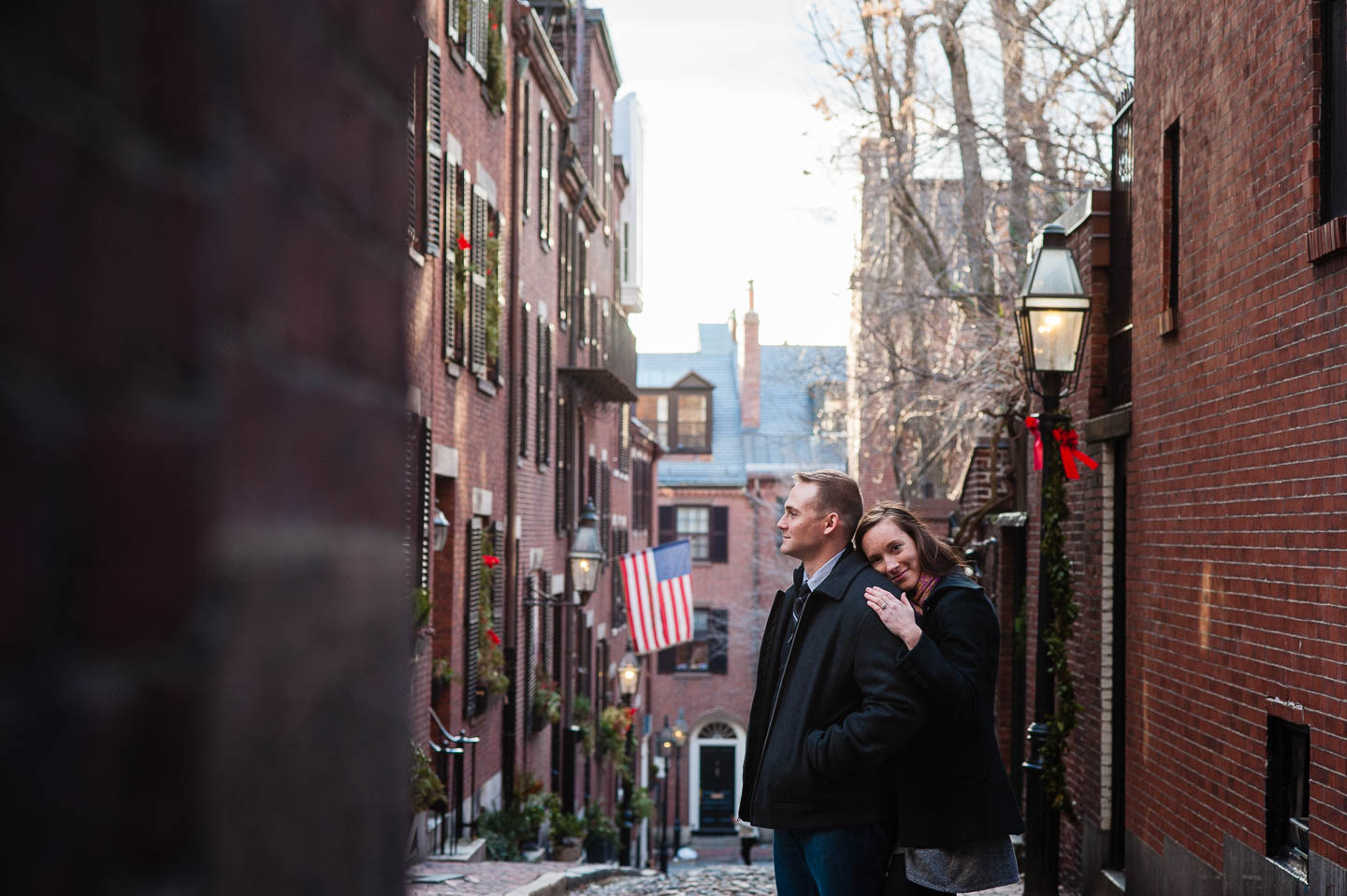 A couple poses for a photograph at the top of Acorn Street in Boston Massachusetts during there engagement session 