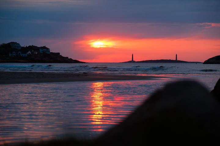 Twin lighthouses are silhuetted at sunrise of Good Harbor beach in Gloucester ma  