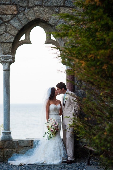beautiful couple kisses by the ocean during their hammond castle wedding