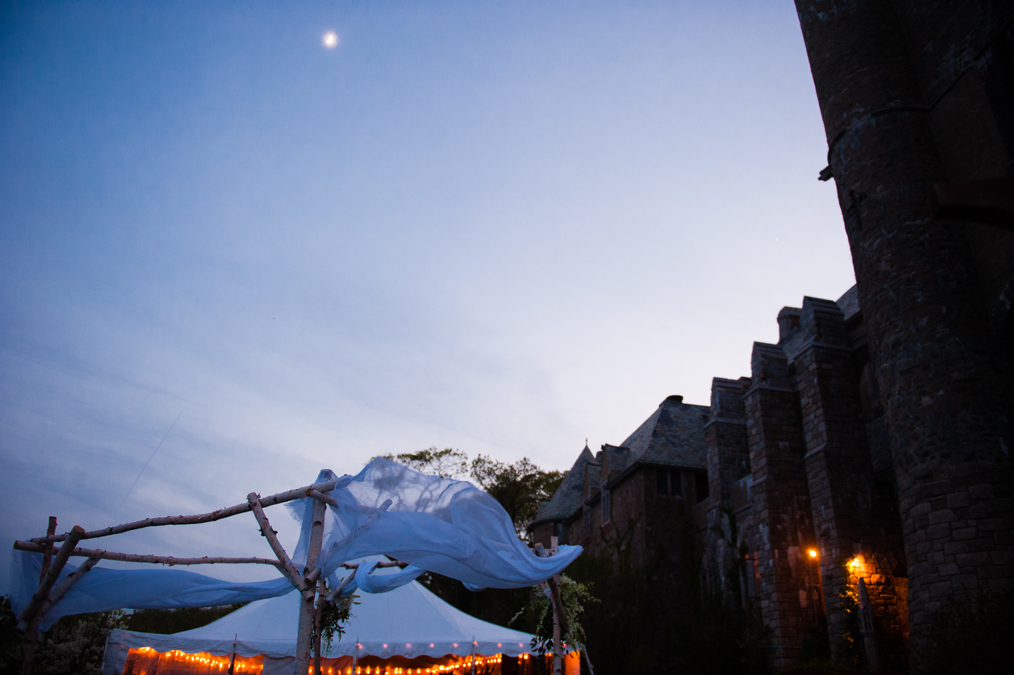 the tent and chuppah in gorgeous early evening light during the wedding reception at hammond castle