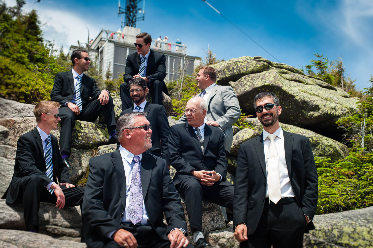 Groom and groomsmen hike in suits for a pre wedding portrait session with amazing views