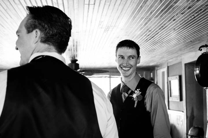 handsome groom gets ready in an old farmhouse before he gets married