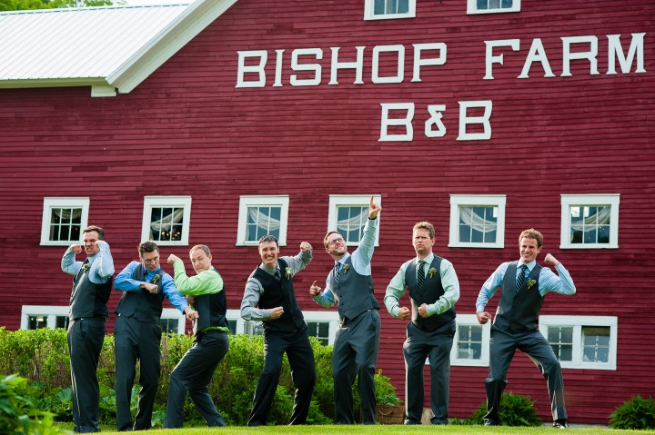 The handsome groom and his groomsmen goof off for a picture at their barn wedding 