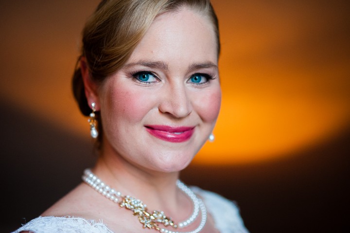 Stunningly beautiful bride with blue eyes and classic pearl jewelry poses for a quick bridal portrait