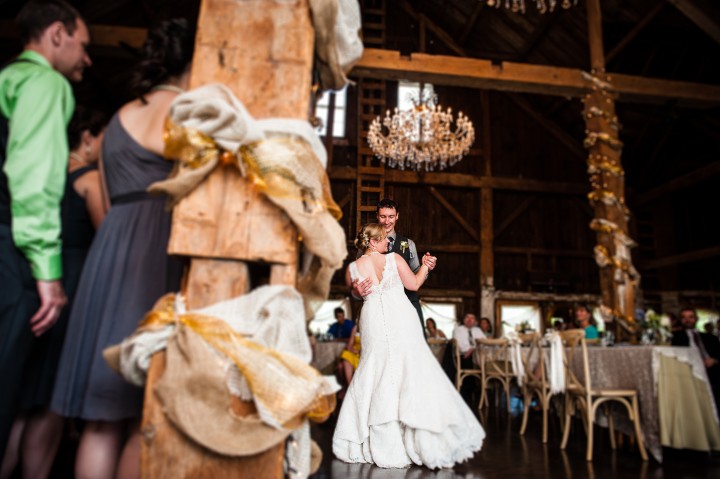 beautiful bride and groom enjoy their first dance in an elegant barn 