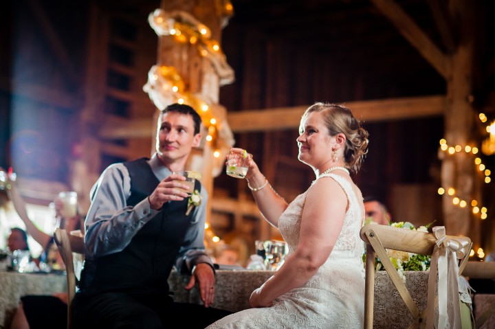 bride and groom cheers after the toasts are complete  during their wedding reception 