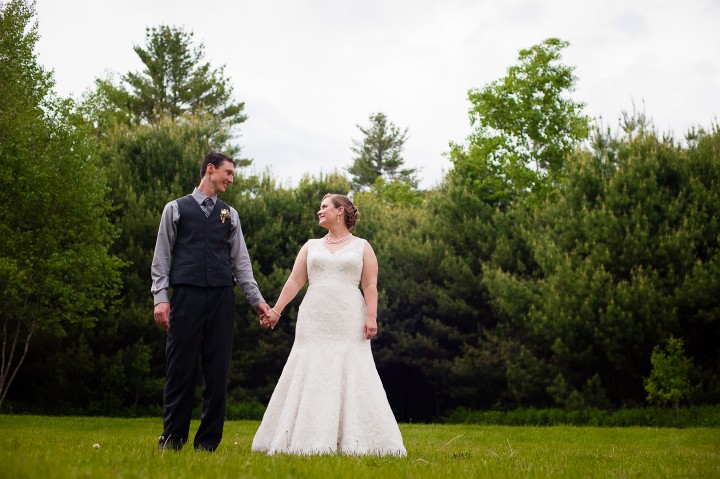 bride and groom stand a meadow for a portrait 