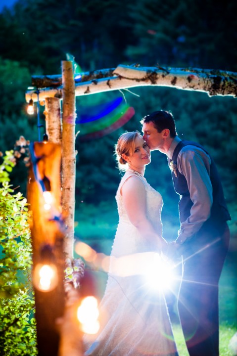 lights and a birch arbor surround the bride and groom 