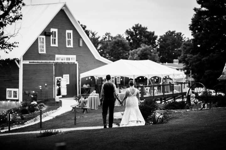 bride and groom hold hands and walk back to reception barn 