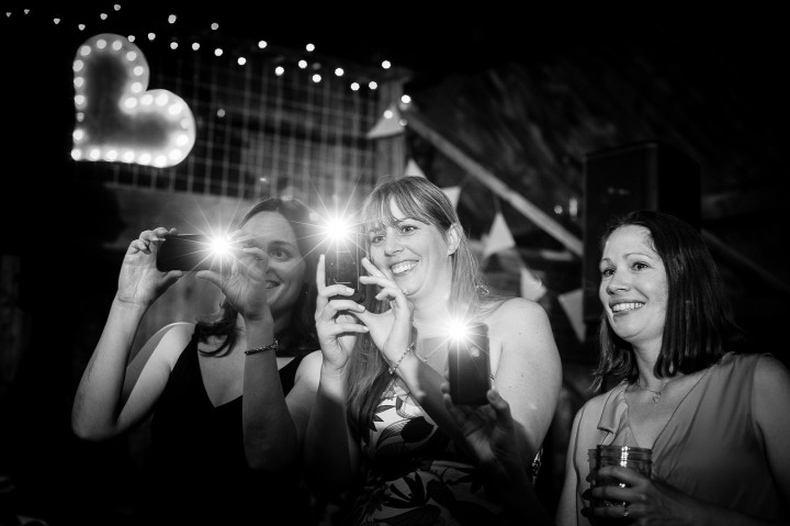 guests taking pictures of people dancing during the wedding 