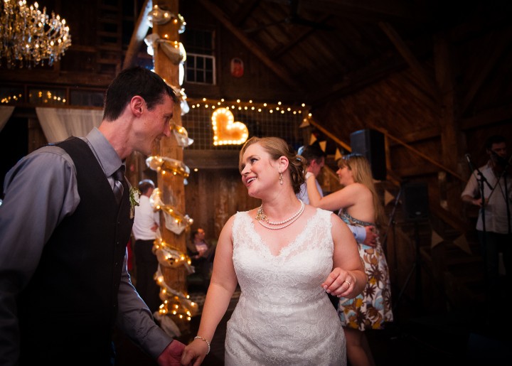 bride and groom dancing with a heart behind them during their barn wedding reception