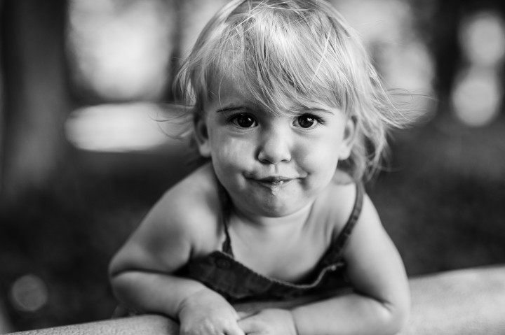 black and white image of little girl smiling at the camera during her portrait session in blue ridge mountains 