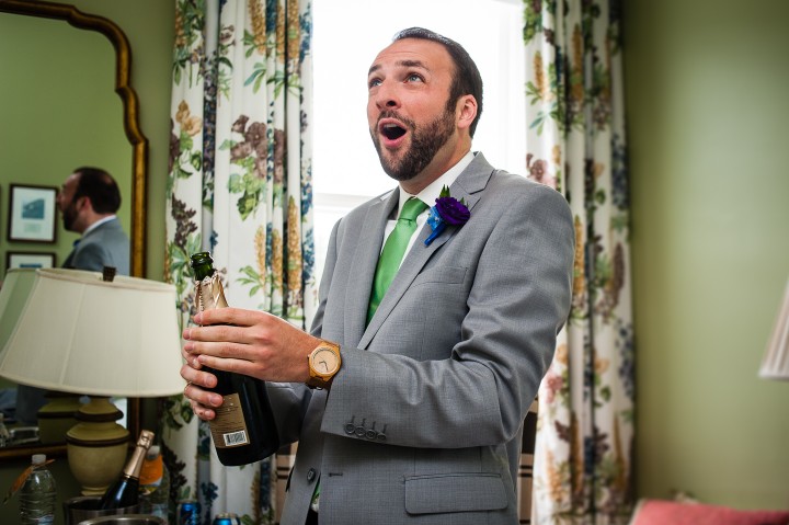 handsome groom during his omni mount washington wedding pops some champagne in celebration