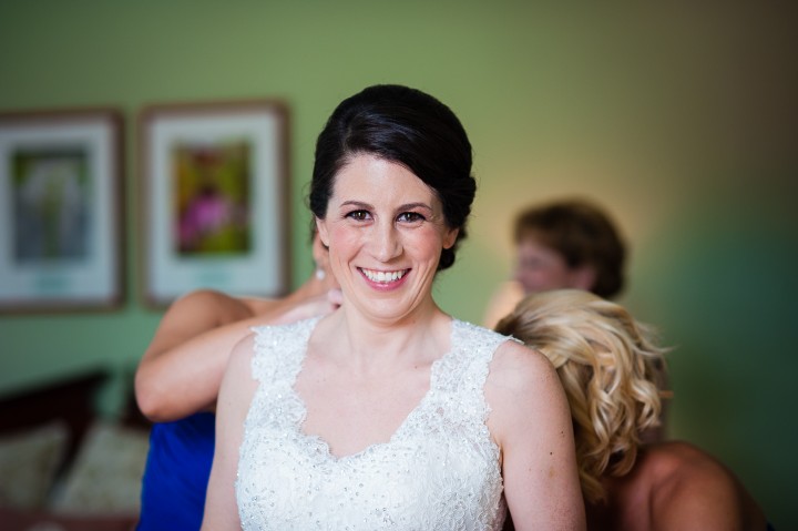 gorgeous bride gets into her gown before her mountain wedding ceremony