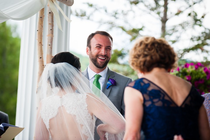 handsome groom smiling during his summertime mountain wedding