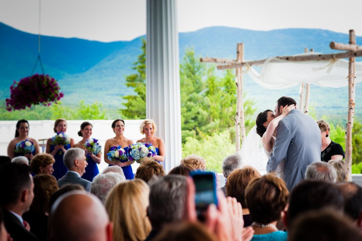 adorable bride and groom share their first kiss as husband and wife during their stunning mountain wedding