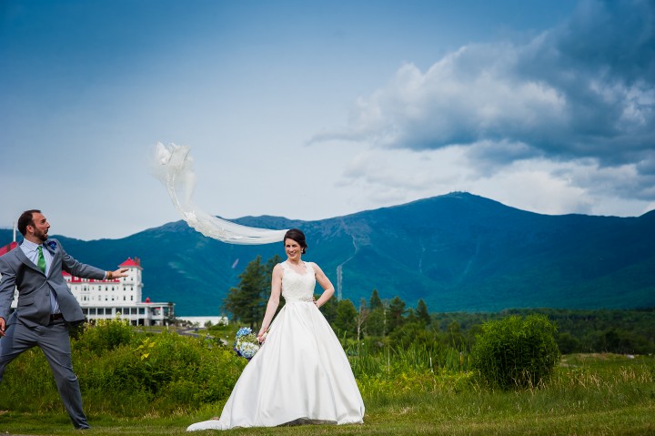 groom tosses brides veil in the air for a fun mountain bridal portrait