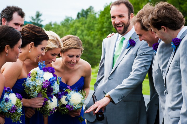 handsome groom shows off his wedding band to the wedding party