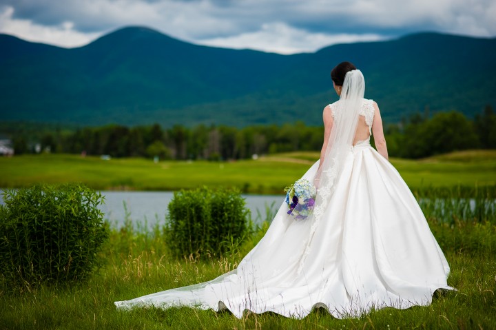 a gorgeous bride shows off the back of her stunning Stella York wedding gown during a mountain bridal portrait