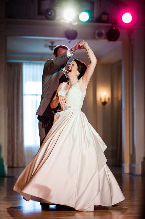 the most adorable bride and groom laugh together as they enjoy their first dance as husband and wife