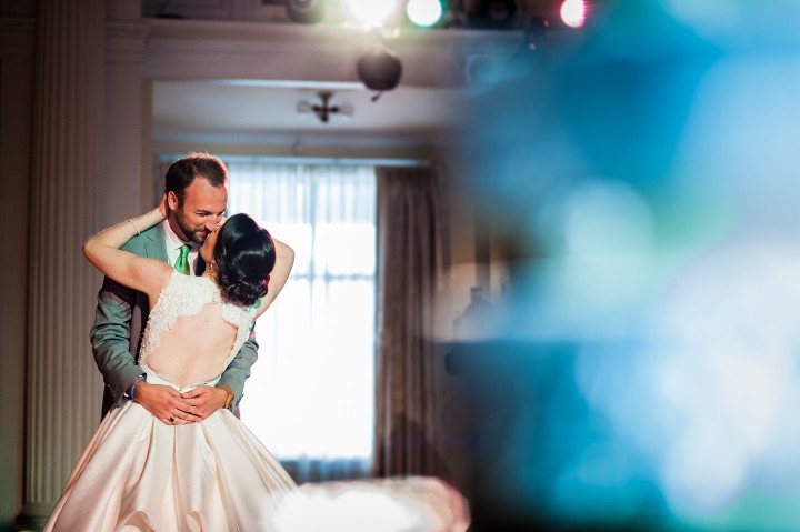 bride and groom embrace during their first dance as husband and wife during their gorgeous summertime wedding reception