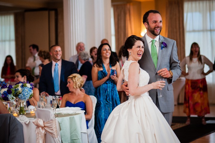 the adorable bride and groom laughing during one of the speeches at their fabulous wedding reception