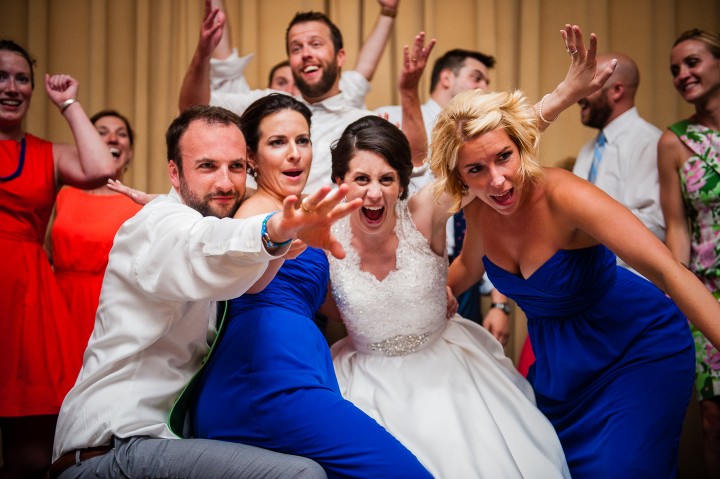 bride and groom with the brides two maid of honors being goofy during the wedding reception