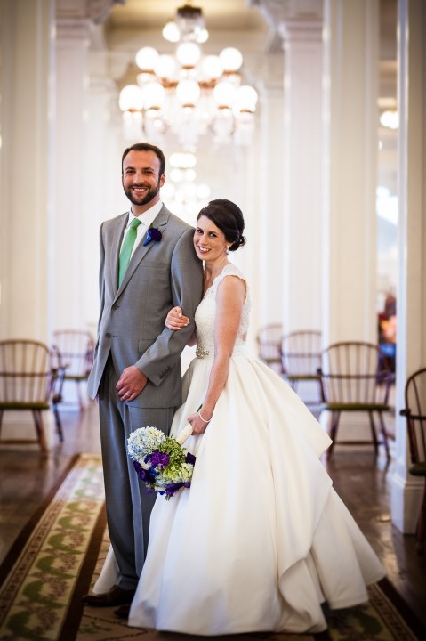 gorgeous bride and groom pose in the great hall inside the beautiful Omni Mount Washington Hotel during their wedding reception