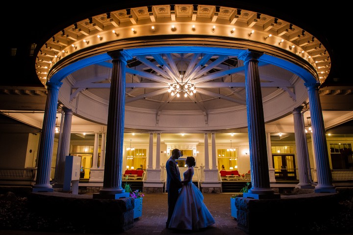 bride and groom pose for an end of the night image in front of the gorgeous mount washington hotel 