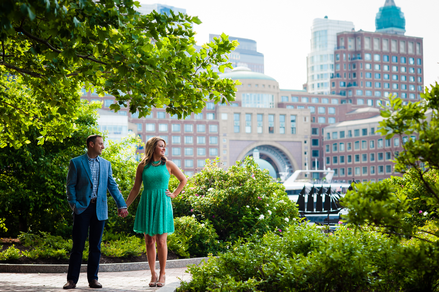 beautiful couple holds hands in front of boston skyline during their city engagement session