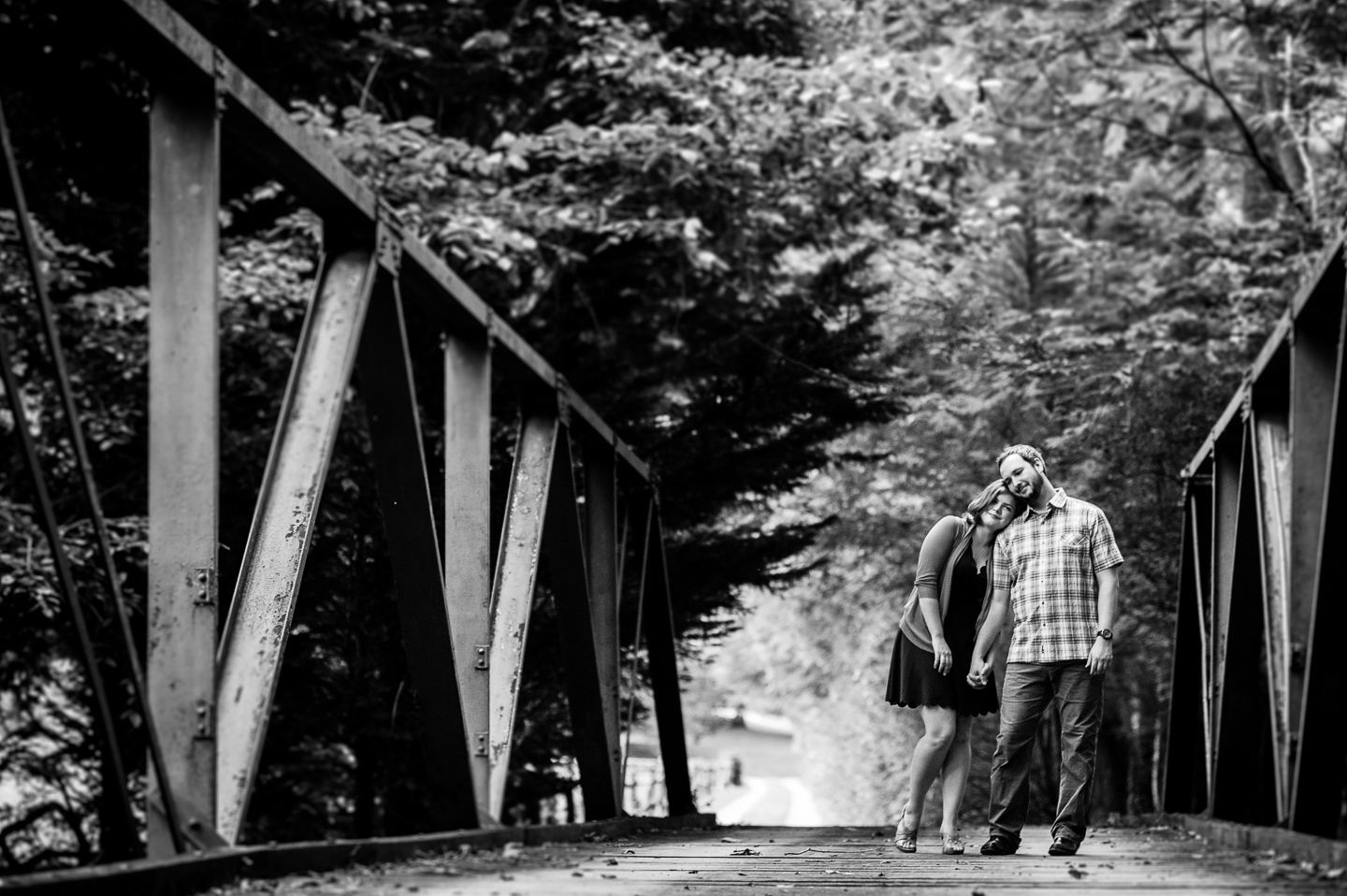 Gorgeous bride and groom pose on old wooden bridge during their wedding party outside Asheville NC