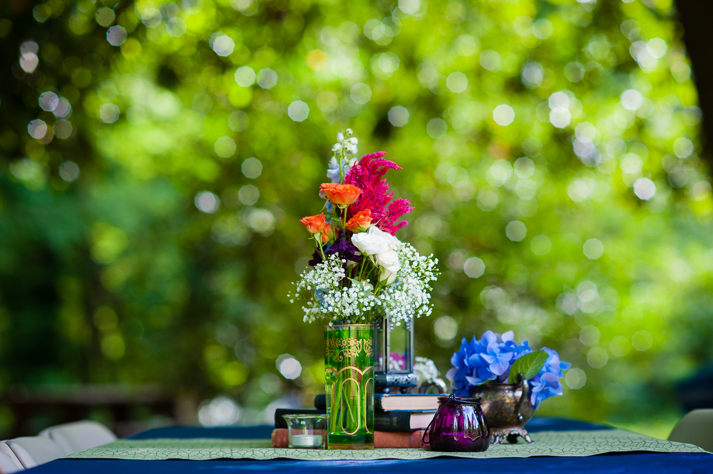 handpicked wildflowers with candles and books decorated the picnic tables during this crafty diy backyard asheville wedding