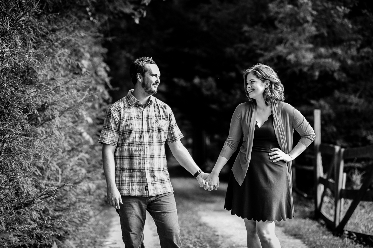 adorable bride and groom hold hands and steal glances at each other during their wedding portraits