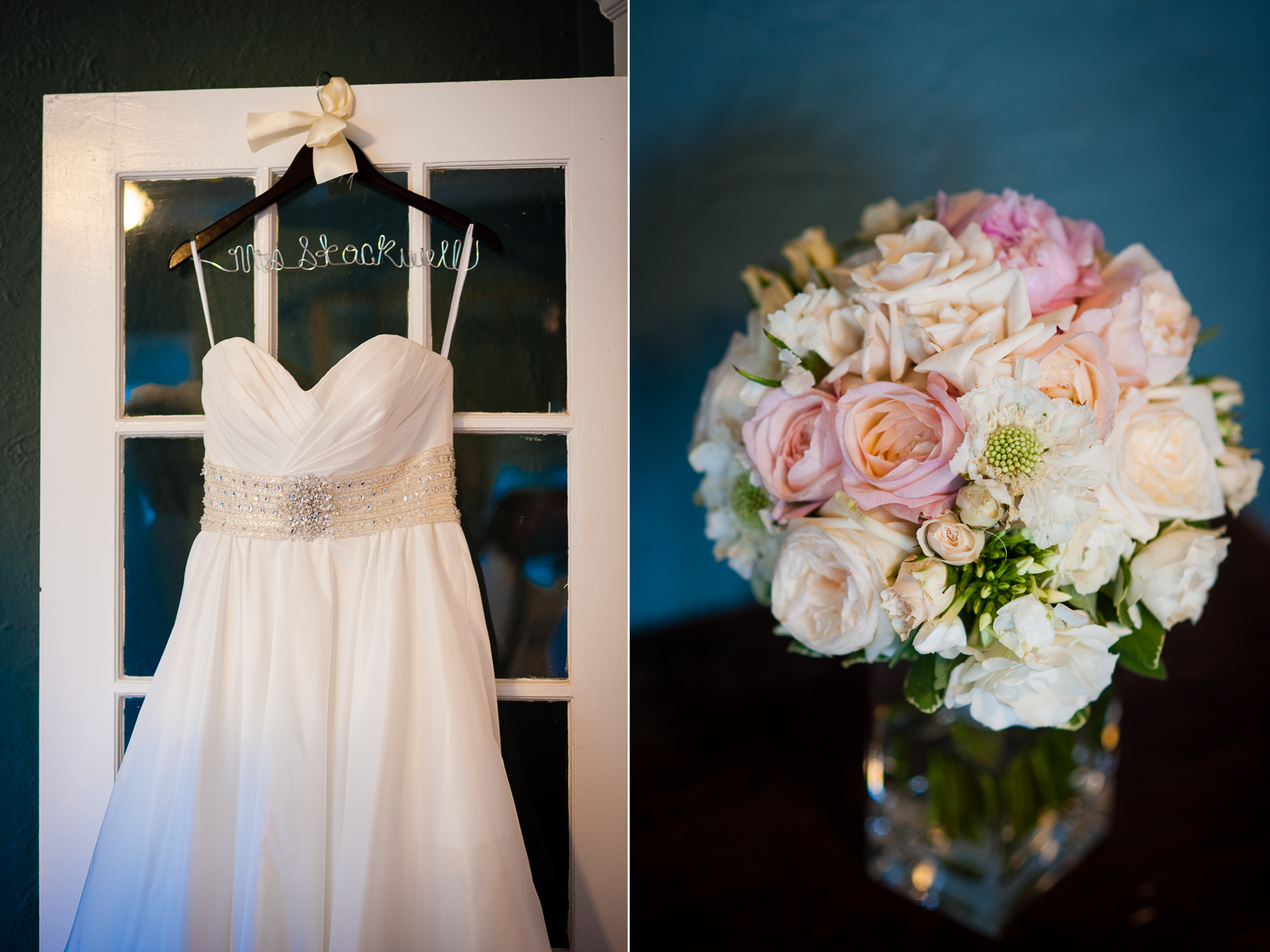 beautiful wedding gown hangs against white door while a stunning bouquet is shown on a wooden table