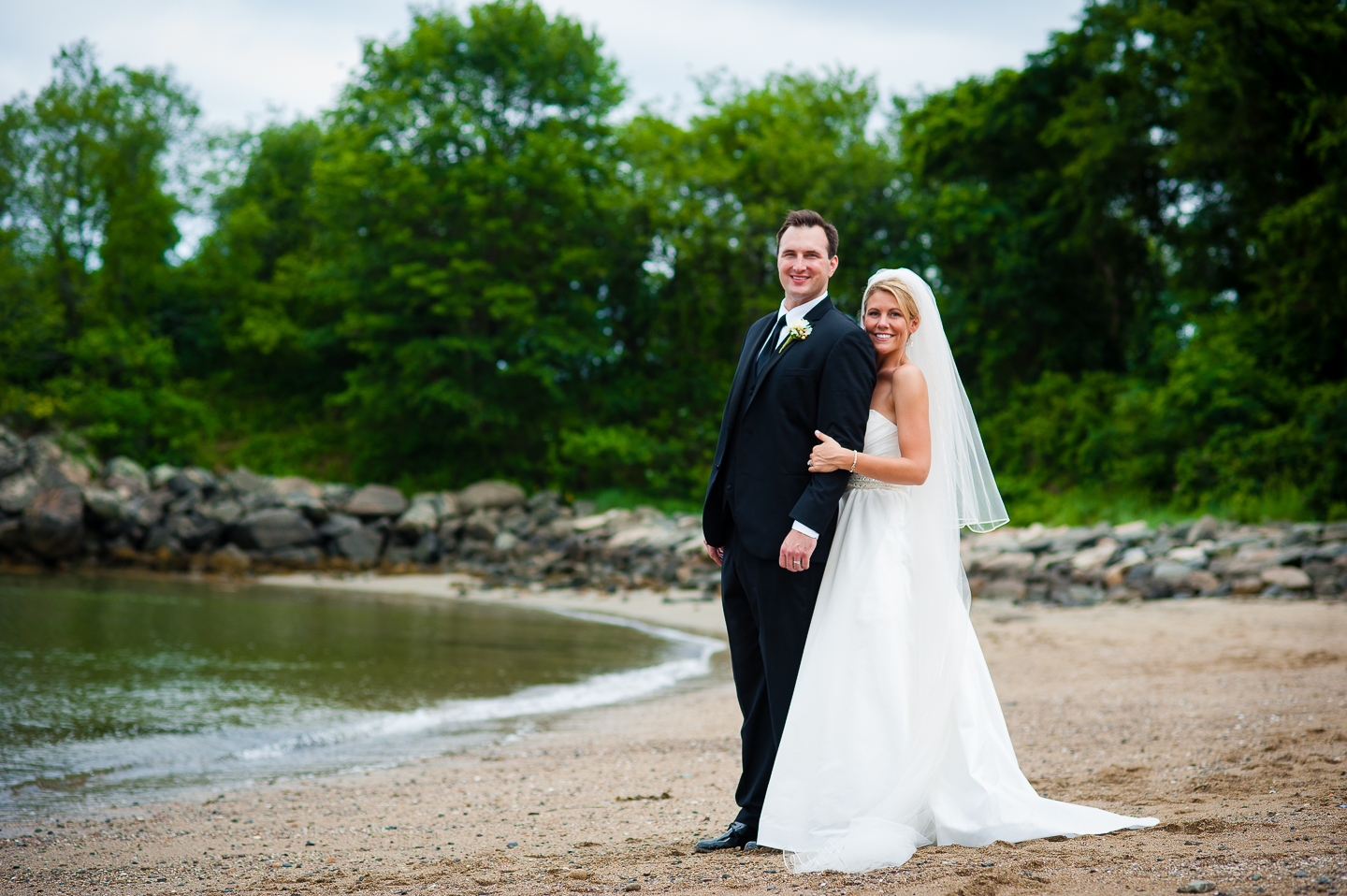 beautiful bride and groom pose on the beach during their seaside destination wedding