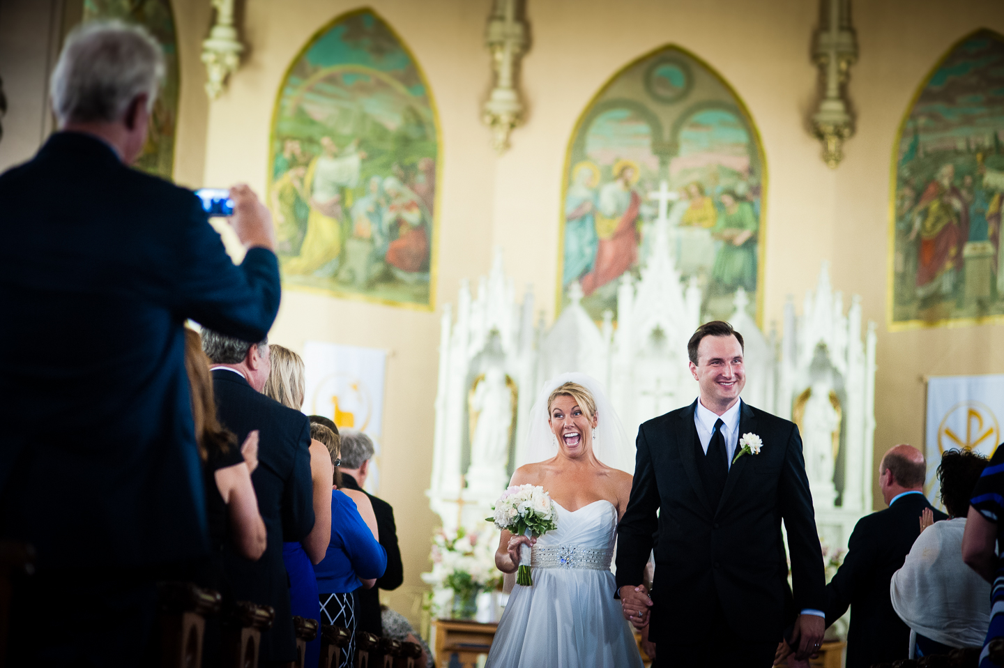 a very happy bride and groom walk down the aisle  as husband and wife