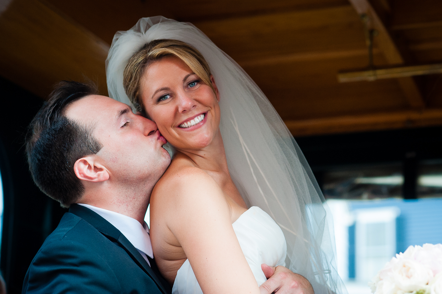 the groom gives his gorgeous bride a kiss on the cheek 