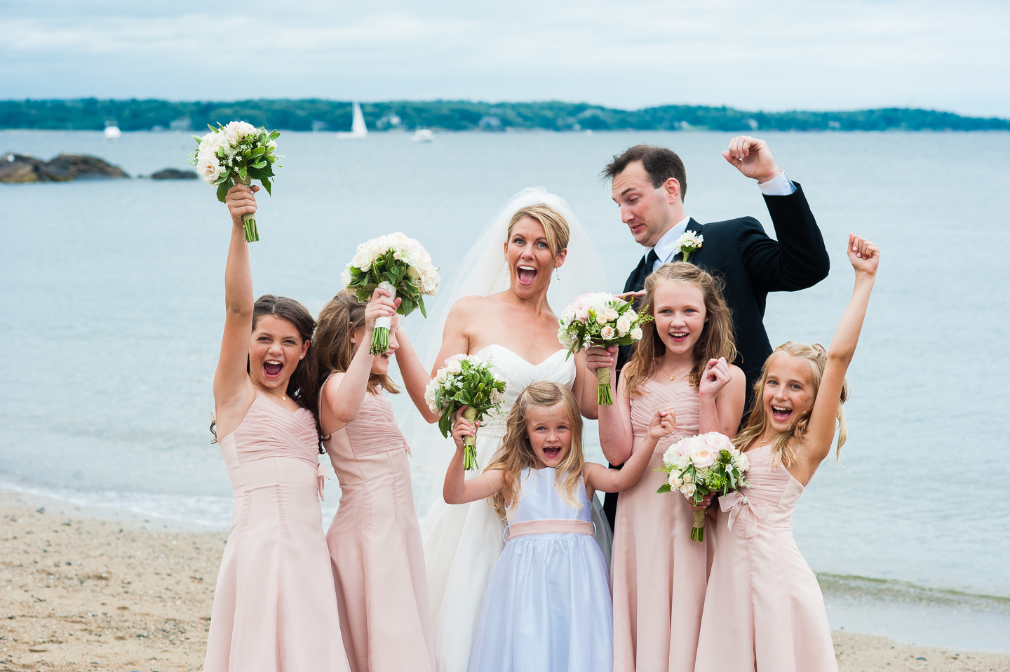 the bride and groom with their adorable jr bridesmaids all cheering 