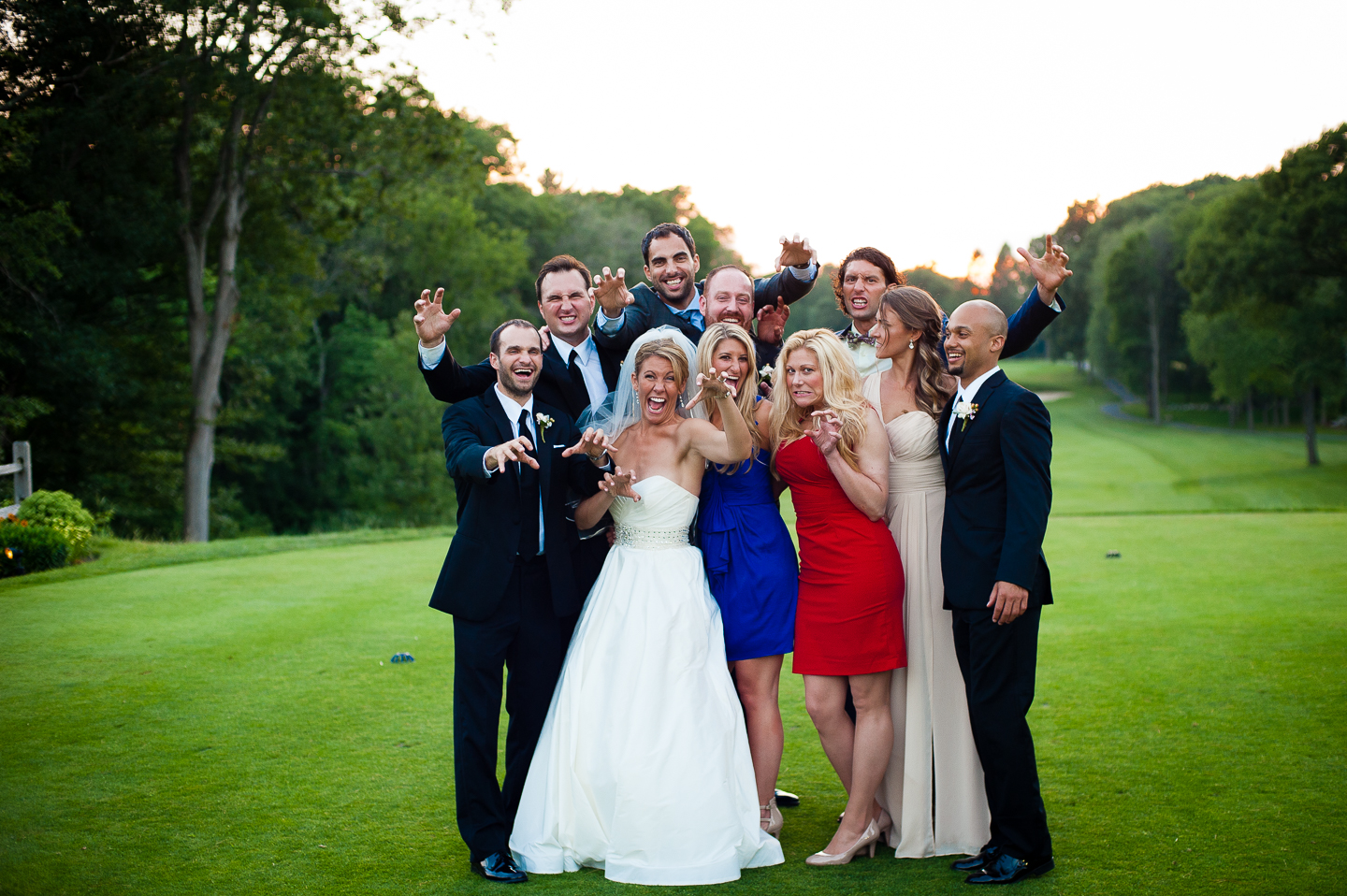 the bride and groom with their friends goofing off on the golf course 