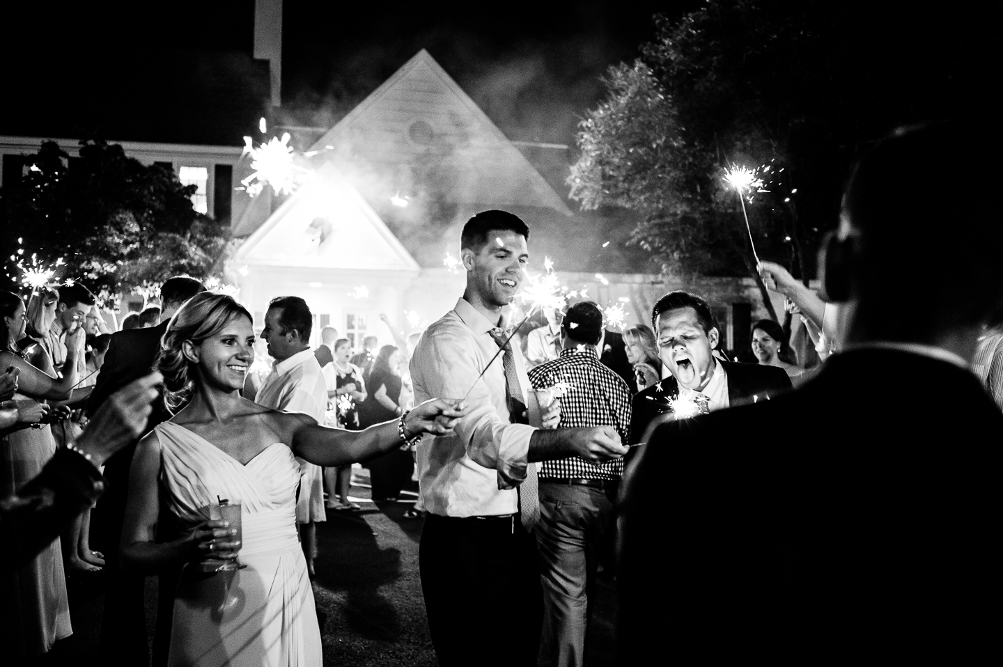 wedding guests lighting the sparklers in preparation for a end of the night sparkler sendoff 