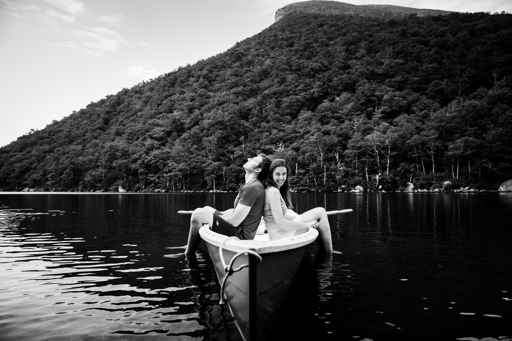 adorable couple sit back to back on their blue row boat 