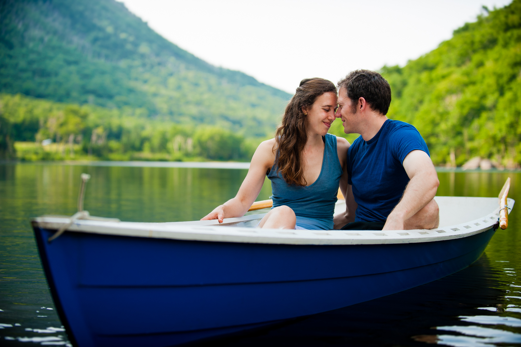 adorable engaged couple embrace during their adventurous engagement session on a lake 