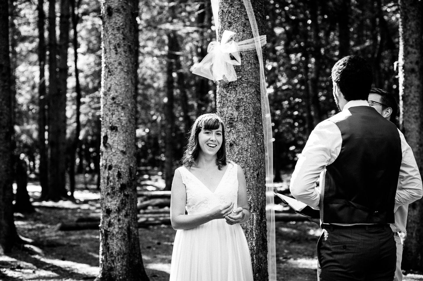 beautiful bride laughs during her intimate forested wedding ceremony 