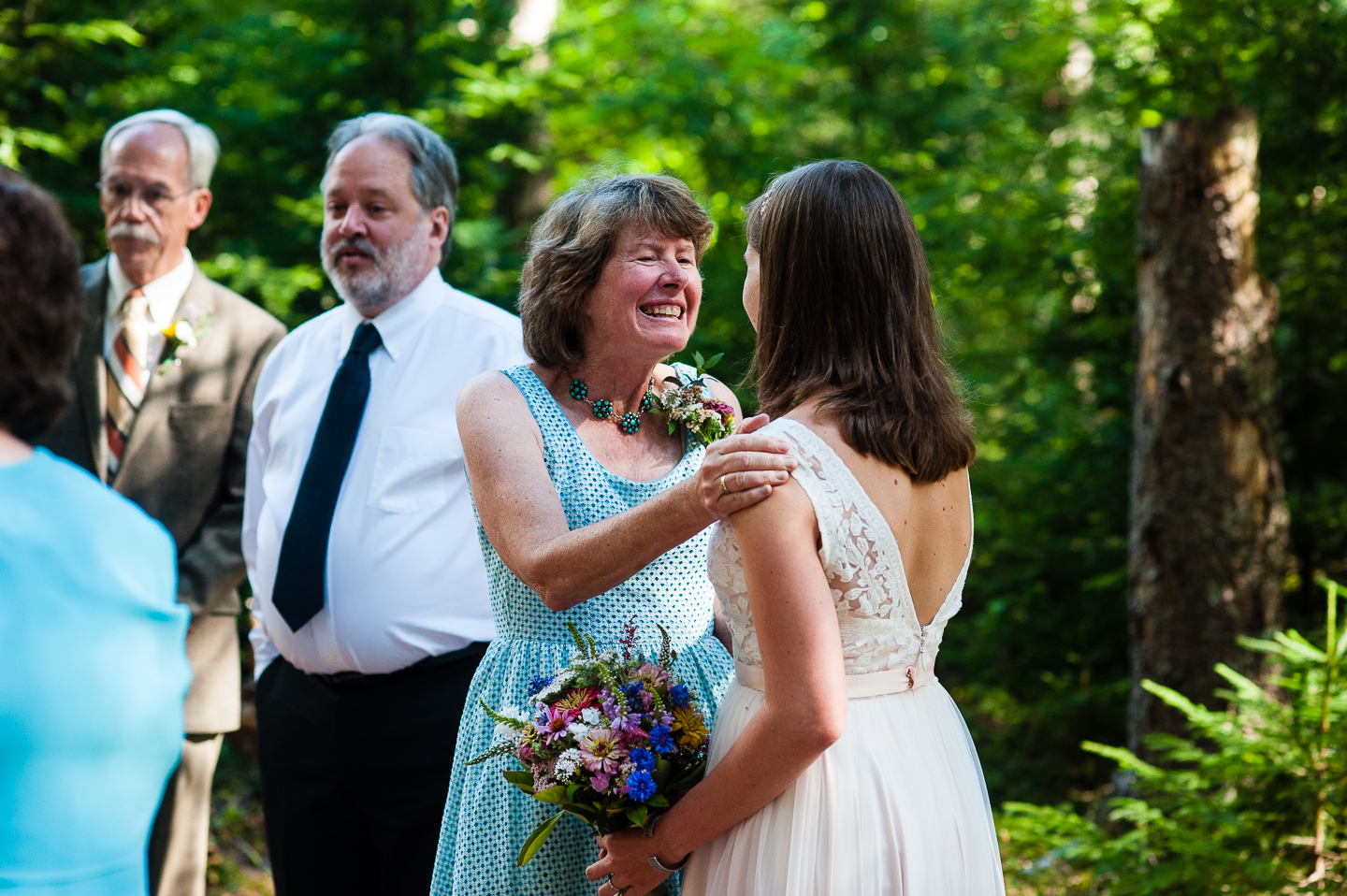 brides mom congratulates thee newly married bride and groom