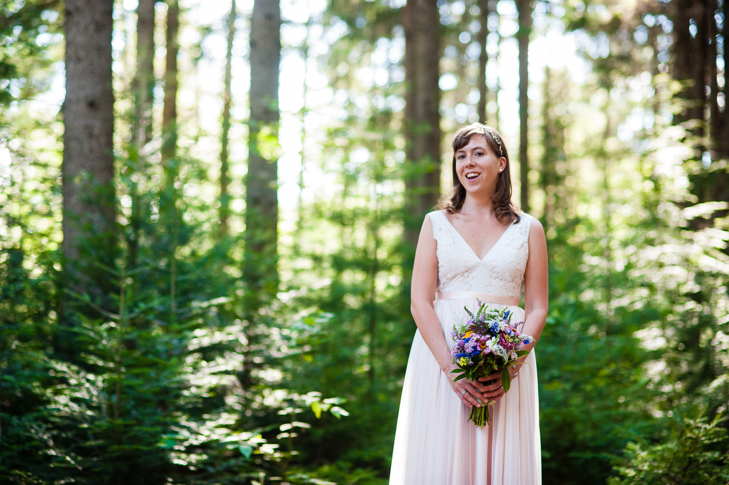 Gorgeous bride poses for a bridal portrait in the woods