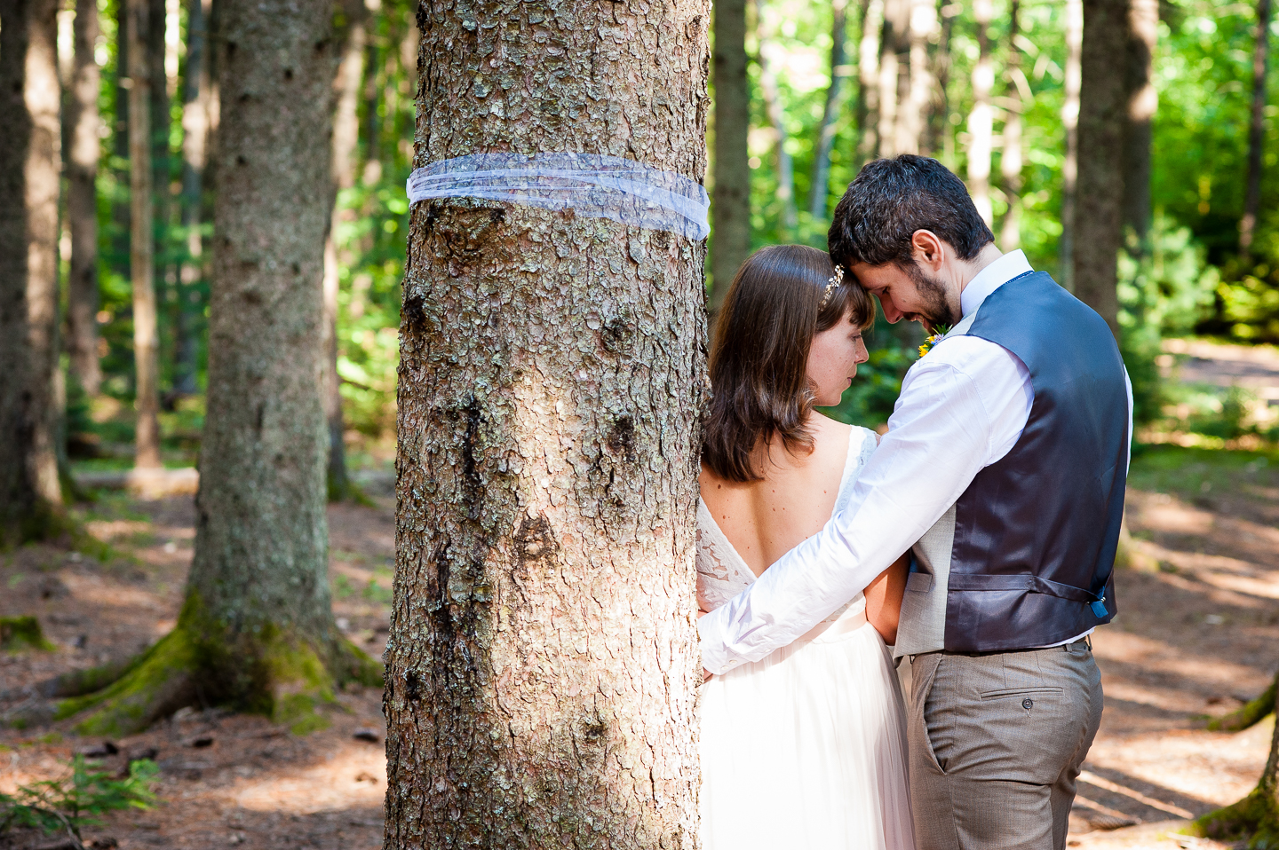 Bride and Groom embrace during their couples portraits in the forest