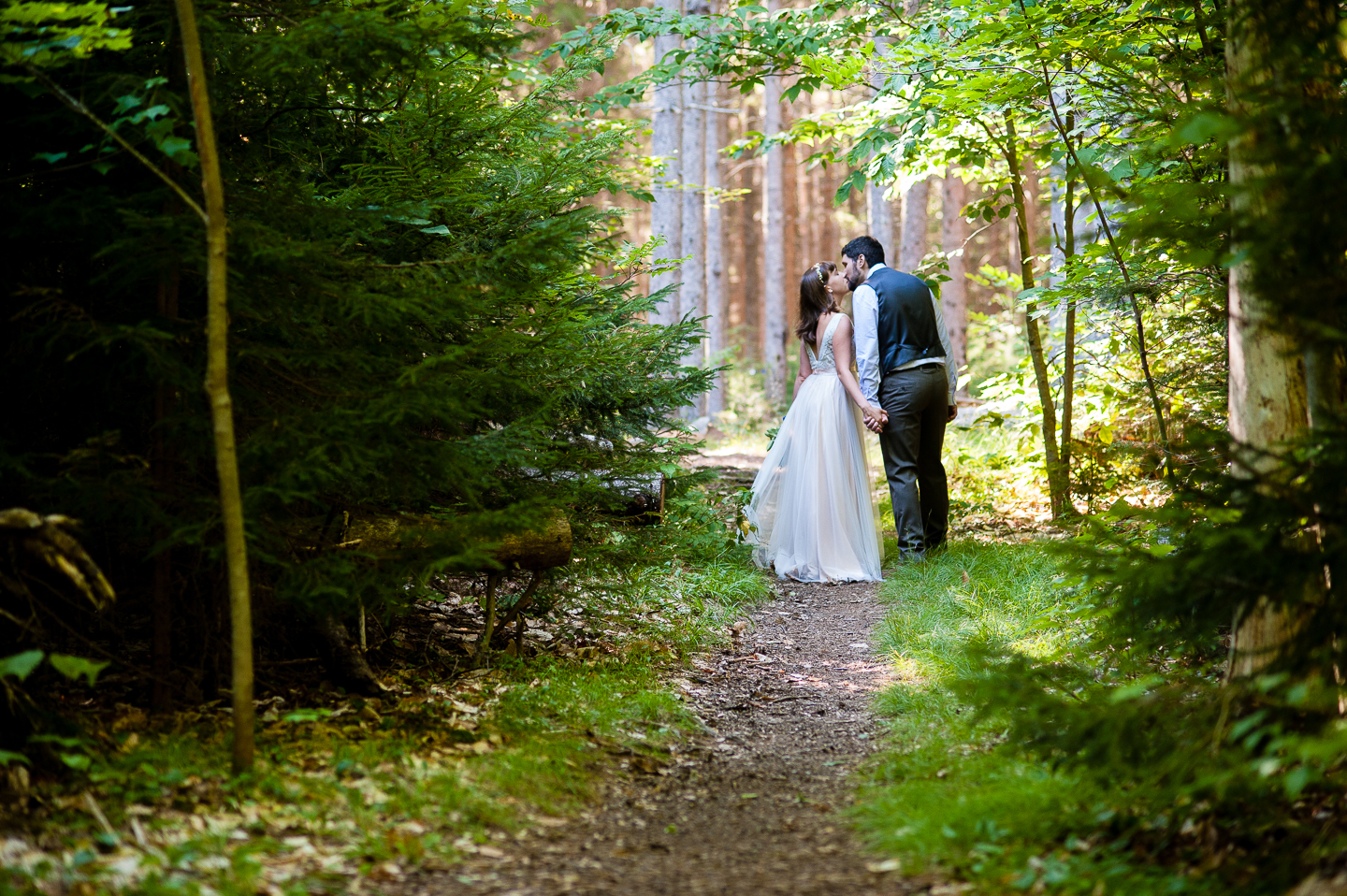 Couple kissing on a gorgeous wooded path