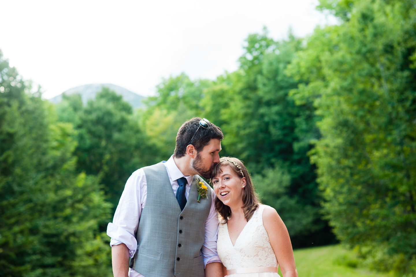 handsome groom gives his bride a kiss on the head