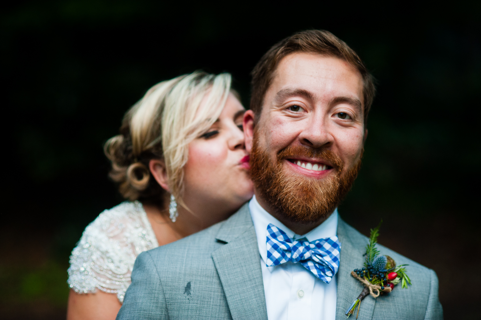 Beautiful bride gives her groom a kiss on the cheek during their wedding a beautiful summer camp wedding